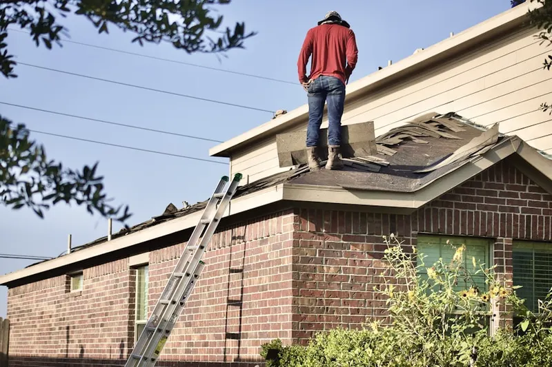 Professional roofer working on a residential roof in Purcell